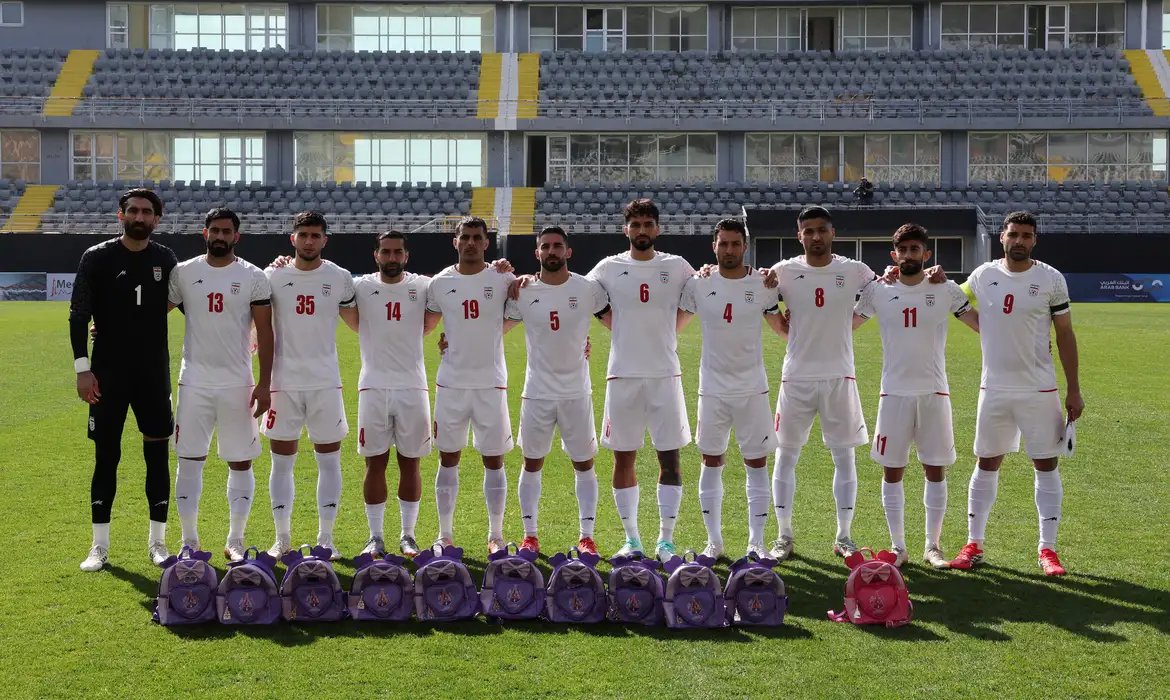 Jogadores iranianos seguram mochilas em protesto por meninas mortas